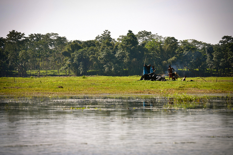 Men cooking at a patch of land that has appeared out from the beel