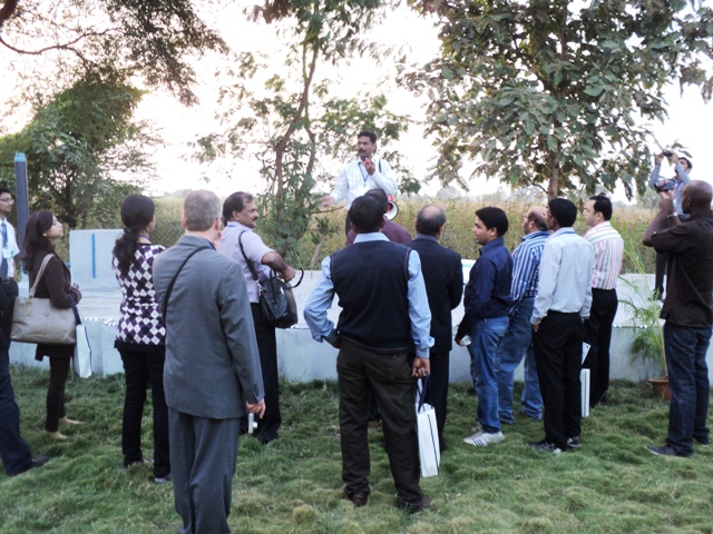 Conference participants standing near the underground anaerobic baffled reactor