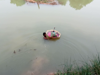A villager crosses the canal by carrying a bag with his clothes in an umbrella. (Pic courtesy: Gurvinder Singh)
