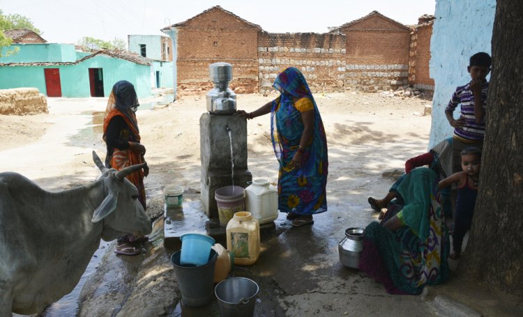 Women fill water from one of the taps at Pipara.