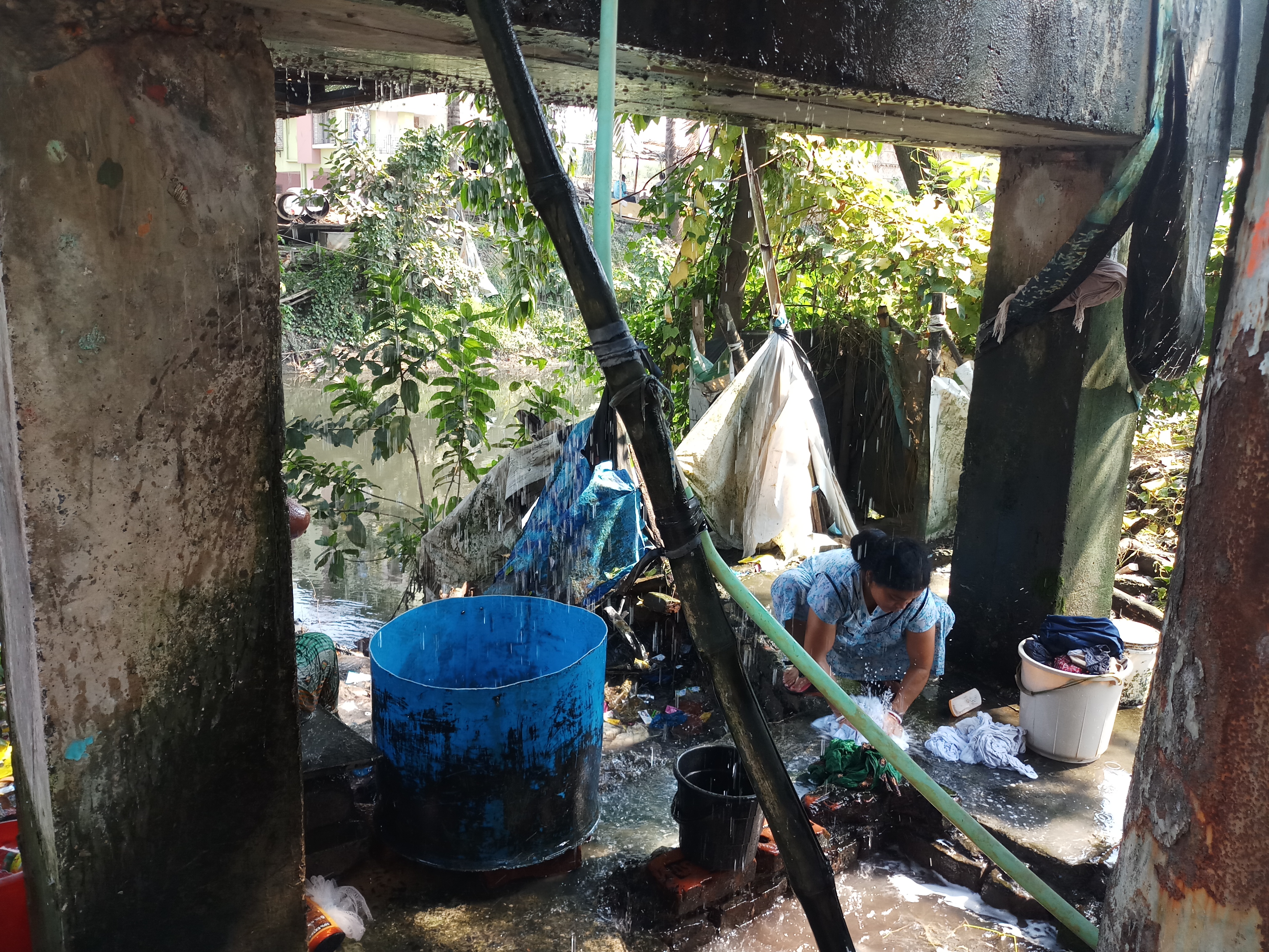 Women wash clothes under the leaking pipe. (Pic by Gurvinder Singh)