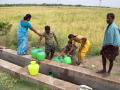 Villagers collecting borewell water from a private farmland (Source: IWP Flickr photos)