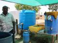 Alagesan with the barrel used to ferment cow dung