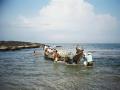 Fishermen launching their boat into the sea