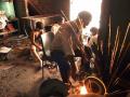 Boys sort discarded computer parts as sparks fly from a grinding machine.  (Image: Greenpeace, Flickr Commons; CC BY-ND 2.0)