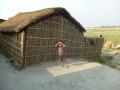 A boy stands outside his home on a spur