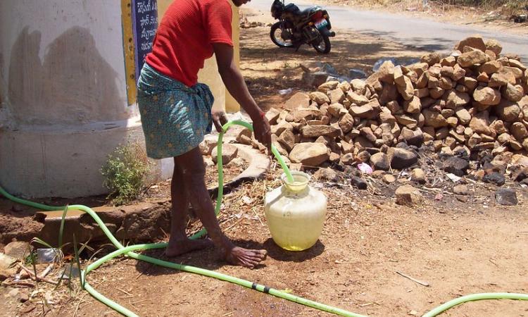 Farmer taking water from a hand pump (Source: IWP Flickr photos)