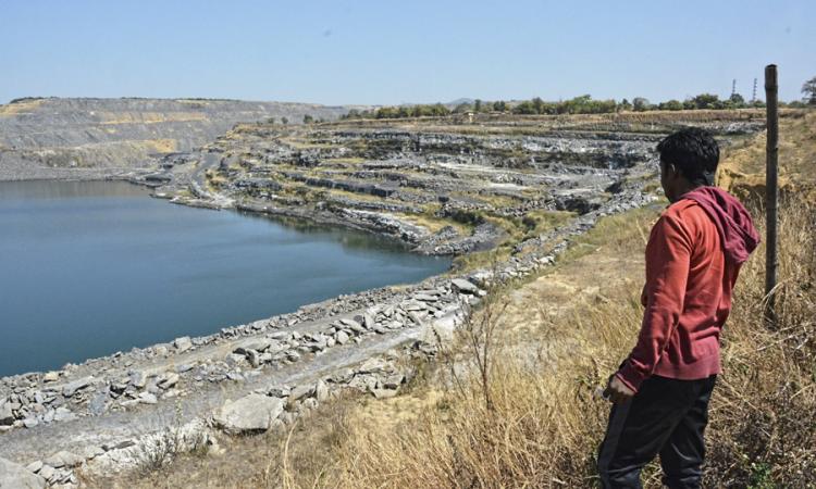 A villager looks at the changing landscape due to coal mines at Kosampalli village in Raigarh.