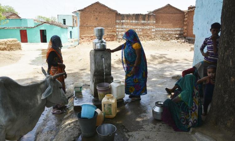 Women filling water from a tap (Source: IWP Flickr photos)