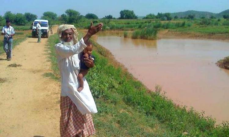 A villager shows the rainwater harvesting structure in Aravalli hills.