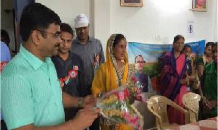 Sudam Khade, collector, Sehore, felicitates a woman from the community for their efforts in ending open defecation.